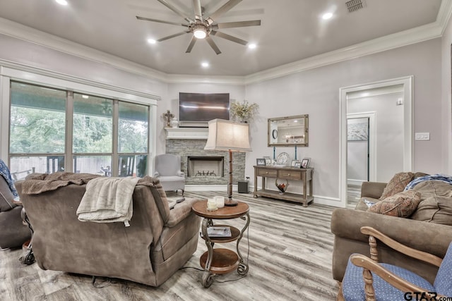 113 Stuart St, Arp, TX 75750 - living area with ceiling fan, crown molding, a fireplace, and light wood-type flooring