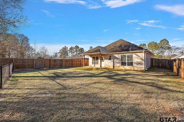 rear view of property featuring a yard