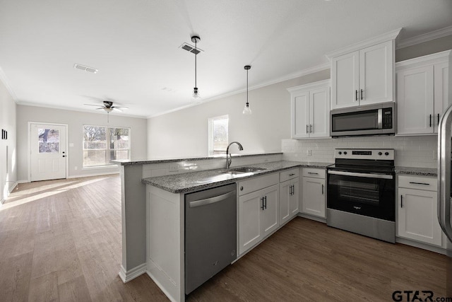 kitchen with backsplash, kitchen peninsula, ceiling fan, appliances with stainless steel finishes, and white cabinetry