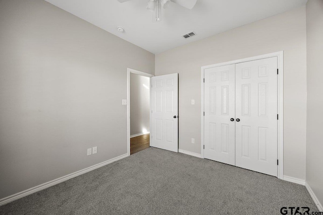 unfurnished bedroom with carpet, a closet, and ceiling fan