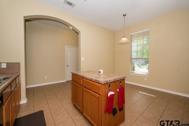 kitchen with a center island, light tile patterned floors, and hanging light fixtures