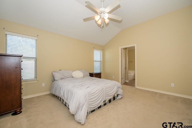 bedroom featuring ceiling fan, carpet floors, ensuite bathroom, and vaulted ceiling