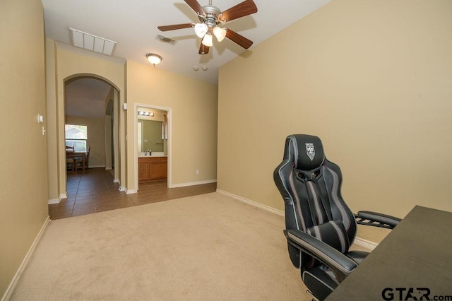 unfurnished office featuring carpet floors and ceiling fan