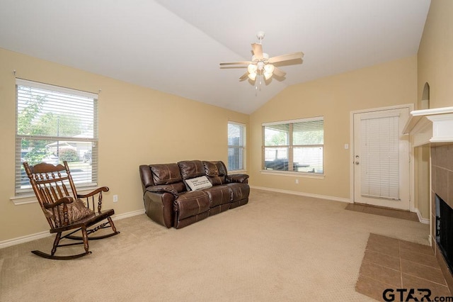 living room featuring carpet flooring, a tile fireplace, a wealth of natural light, and lofted ceiling