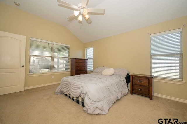 carpeted bedroom with multiple windows, ceiling fan, and lofted ceiling