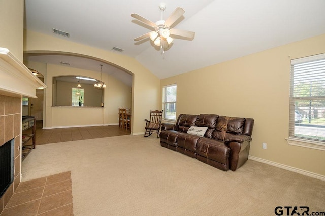 carpeted living room with ceiling fan, a fireplace, and vaulted ceiling