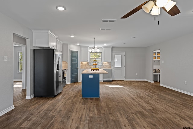 kitchen featuring white cabinetry, hanging light fixtures, a center island, stainless steel appliances, and dark wood-type flooring