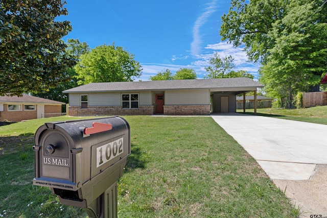 ranch-style home featuring brick siding, driveway, a front lawn, and fence
