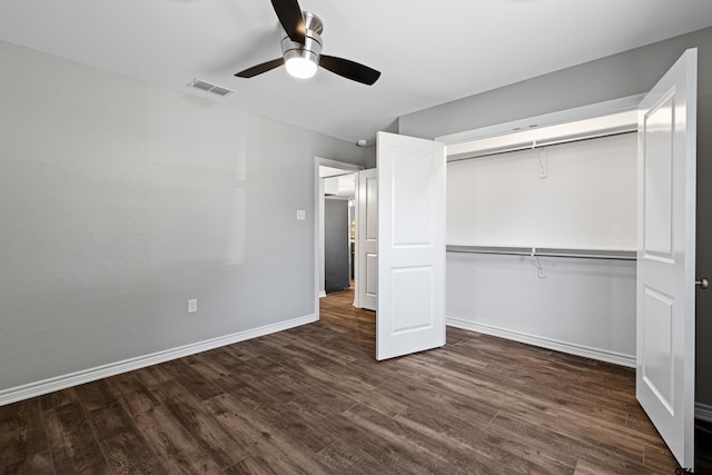 unfurnished bedroom featuring dark wood-type flooring, a closet, and ceiling fan