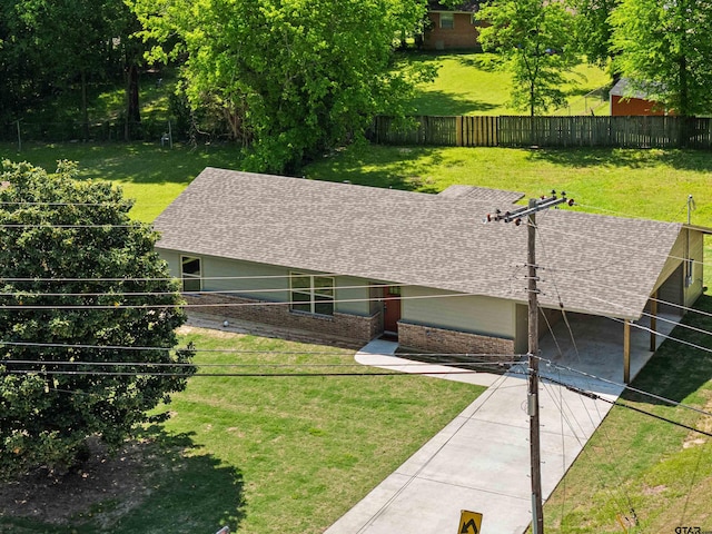 ranch-style home featuring a front lawn, brick siding, a shingled roof, and a fenced backyard