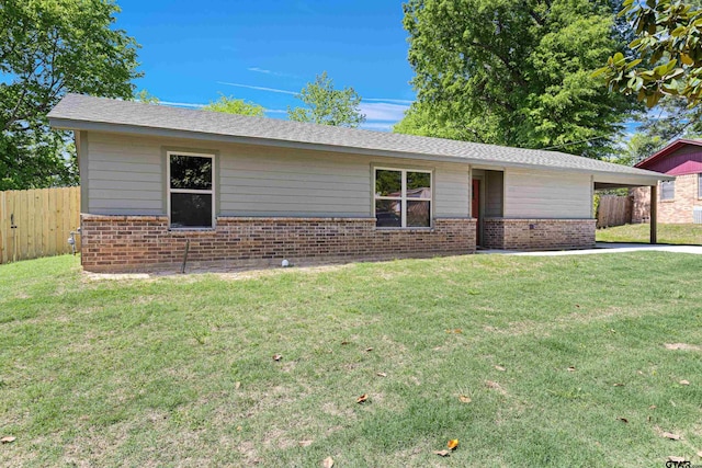 ranch-style house with a front lawn, brick siding, fence, and an attached carport