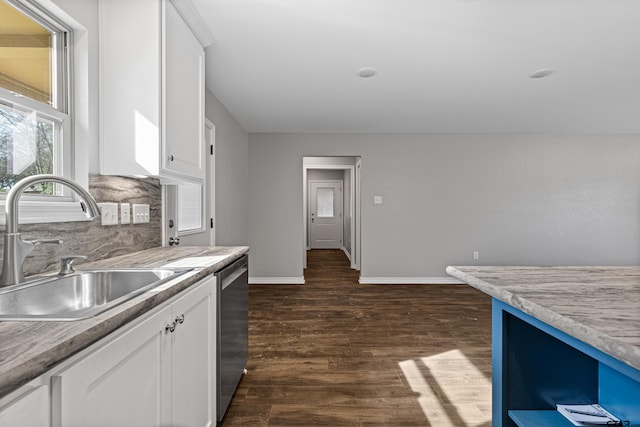 kitchen featuring sink, white cabinetry, stainless steel dishwasher, dark hardwood / wood-style floors, and decorative backsplash