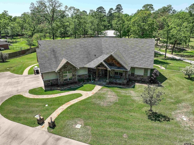 14647 County Road 2337, Tyler, TX 75707 - view of front of property with a shingled roof, fence, stone siding, and a front lawn