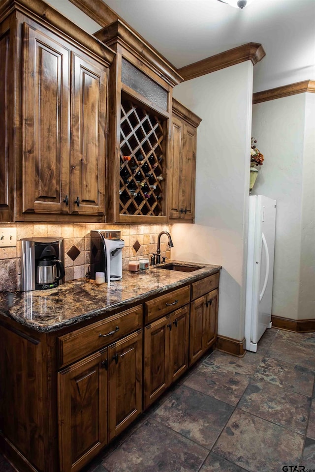 14647 County Road 2337, Tyler, TX 75707 - kitchen featuring tasteful backsplash, baseboards, freestanding refrigerator, stone finish floor, and a sink