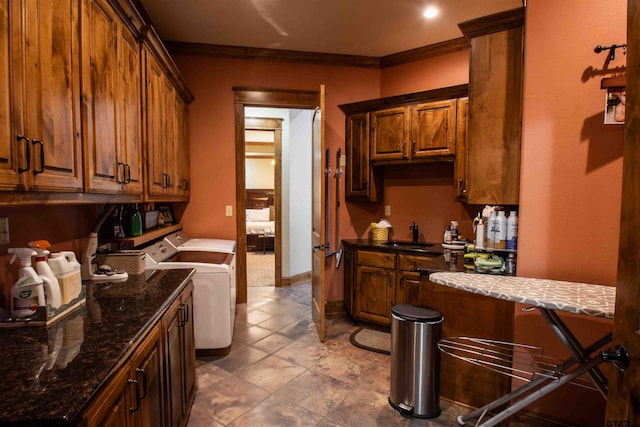 14647 County Road 2337, Tyler, TX 75707 - kitchen featuring baseboards, separate washer and dryer, a sink, ornamental molding, and brown cabinets