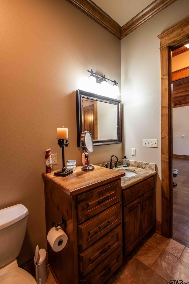 14647 County Road 2337, Tyler, TX 75707 - bathroom featuring vanity, baseboards, ornamental molding, and toilet