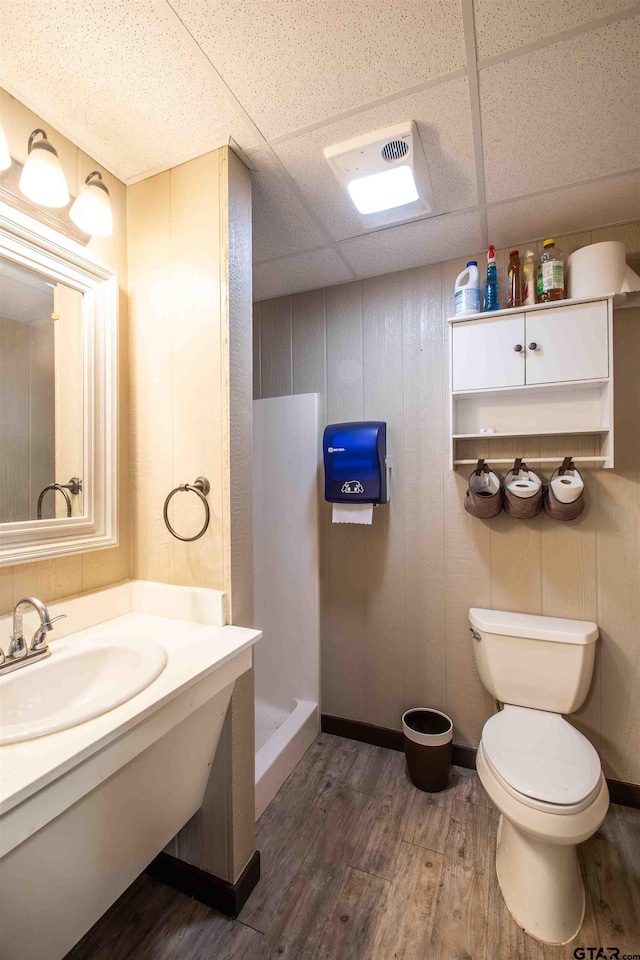 14647 County Road 2337, Tyler, TX 75707 - full bathroom with a paneled ceiling, a shower stall, toilet, wood finished floors, and a sink