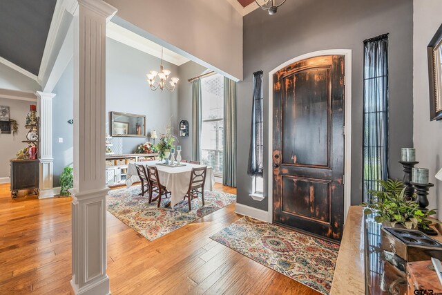 foyer entrance featuring light wood-type flooring and ornate columns