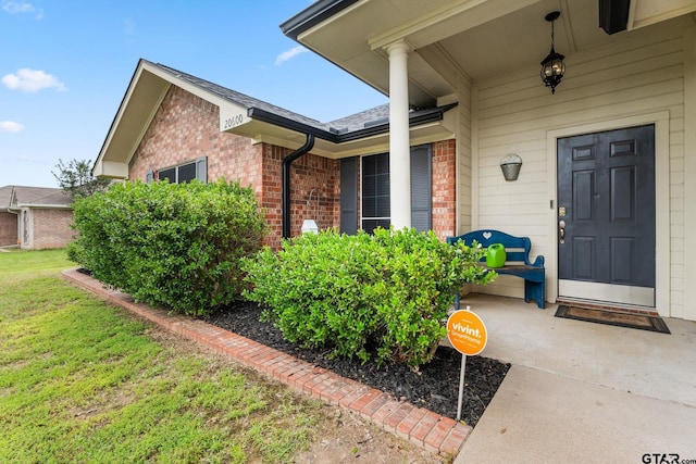 view of exterior entry with a yard