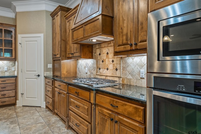 kitchen with stainless steel appliances, crown molding, tasteful backsplash, and brown cabinets