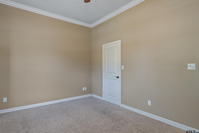 carpeted spare room with crown molding, baseboards, and ceiling fan