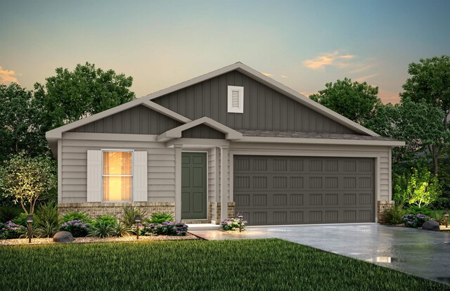 view of front of home with a garage and a lawn