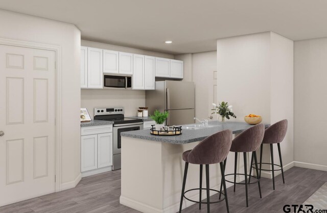 kitchen with light hardwood / wood-style floors, a kitchen bar, white cabinetry, and appliances with stainless steel finishes