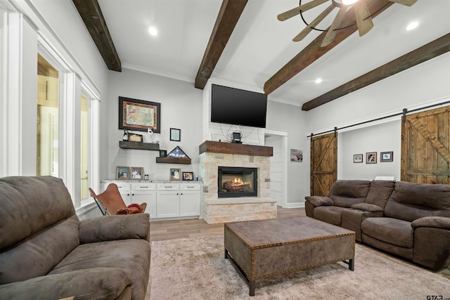 14607 Reserve Ct, Tyler, TX 75707 - living area featuring a barn door, a ceiling fan, light wood finished floors, beam ceiling, and a fireplace
