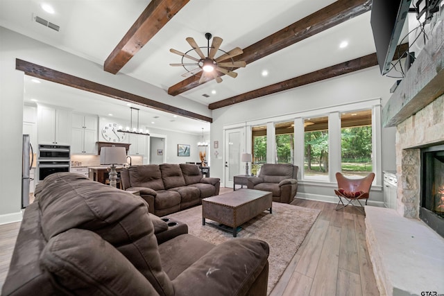 14607 Reserve Ct, Tyler, TX 75707 - living area featuring a fireplace, ceiling fan, beamed ceiling, light wood-style flooring, and recessed lighting