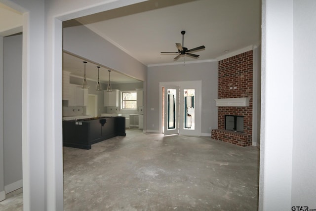 unfurnished living room with crown molding, a brick fireplace, and ceiling fan