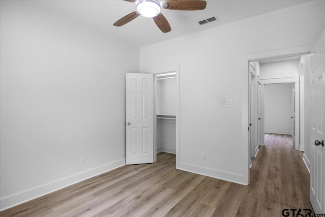 unfurnished bedroom featuring wood finished floors, baseboards, and visible vents