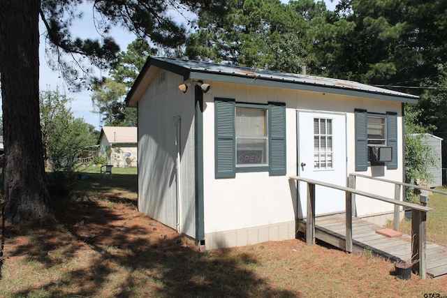 view of property exterior featuring a wooden deck and an outbuilding