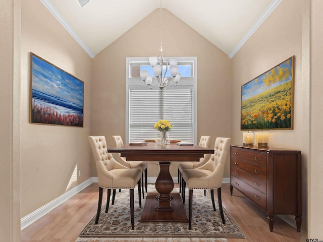 dining area featuring crown molding, lofted ceiling, a chandelier, and light hardwood / wood-style floors