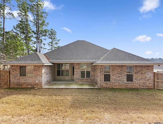 rear view of property with a patio and a lawn