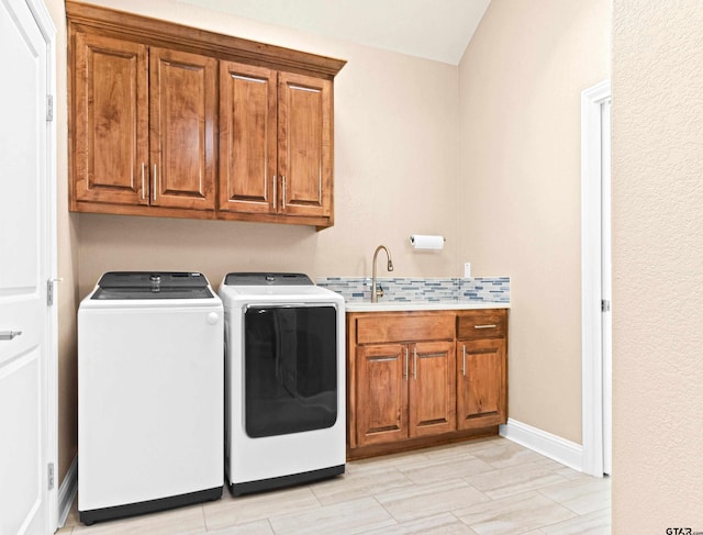 washroom featuring cabinets, sink, and independent washer and dryer