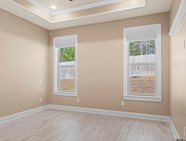 unfurnished room with ceiling fan and a tray ceiling