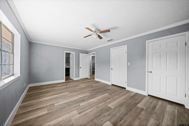 unfurnished bedroom featuring ceiling fan, crown molding, and hardwood / wood-style flooring