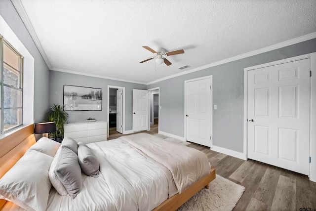 bedroom with ornamental molding, a textured ceiling, ceiling fan, and dark wood-type flooring