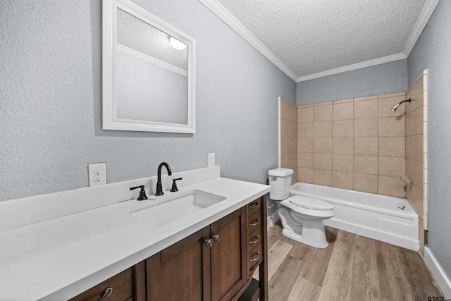 full bathroom featuring tiled shower / bath combo, crown molding, hardwood / wood-style floors, a textured ceiling, and vanity