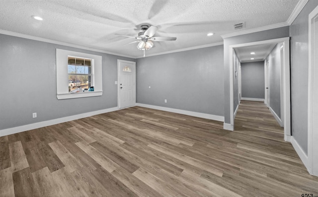 spare room featuring hardwood / wood-style flooring, ceiling fan, ornamental molding, and a textured ceiling