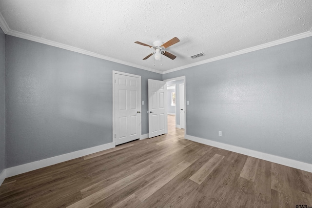 unfurnished room featuring hardwood / wood-style floors, ceiling fan, crown molding, and a textured ceiling