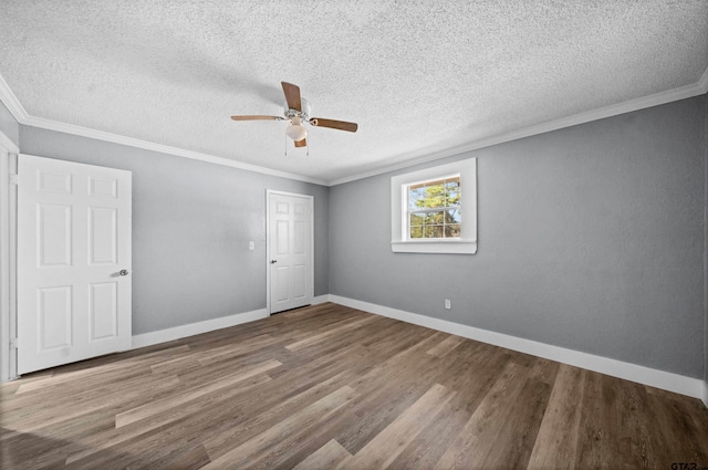 spare room featuring ceiling fan, crown molding, wood-type flooring, and a textured ceiling