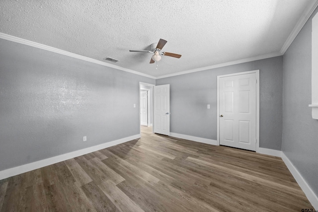 unfurnished room featuring a textured ceiling, ceiling fan, wood-type flooring, and ornamental molding