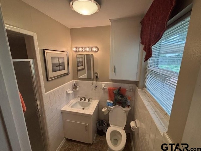 3010 Cook Ln, Longview, TX 75602 - full bathroom with toilet, a stall shower, vanity, tile walls, and a wainscoted wall