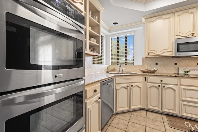 1202 Heather Ln, Longview, TX 75604 - kitchen featuring cream cabinetry, appliances with stainless steel finishes, a sink, ornamental molding, and light tile patterned flooring
