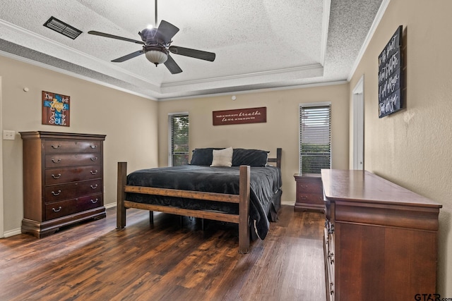 1801 N Fairway, Mount Pleasant, TX 75455 - bedroom featuring a raised ceiling, a textured ceiling, multiple windows, dark wood-style flooring, and ornamental molding