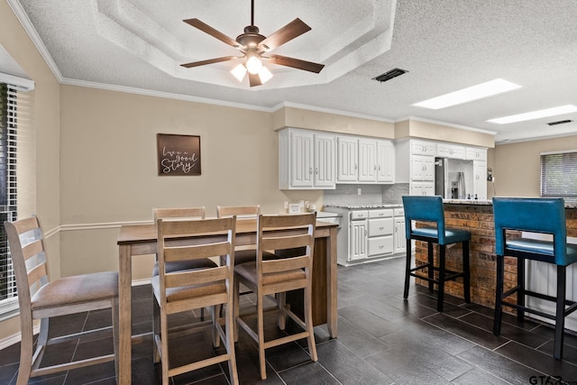 1801 N Fairway, Mount Pleasant, TX 75455 - dining area featuring a textured ceiling, a ceiling fan, dark tile patterned flooring, and crown molding