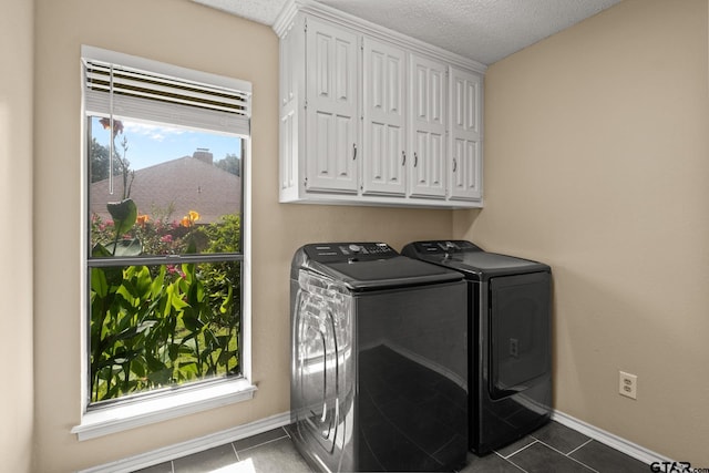 1801 N Fairway, Mount Pleasant, TX 75455 - laundry area with washer and dryer, dark tile patterned flooring, cabinet space, and a textured ceiling