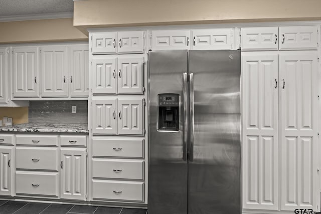 1801 N Fairway, Mount Pleasant, TX 75455 - kitchen featuring stainless steel fridge with ice dispenser, dark tile patterned floors, white cabinetry, crown molding, and light stone countertops