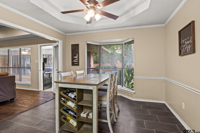 1801 N Fairway, Mount Pleasant, TX 75455 - tiled dining room featuring a ceiling fan, a textured ceiling, crown molding, and a raised ceiling